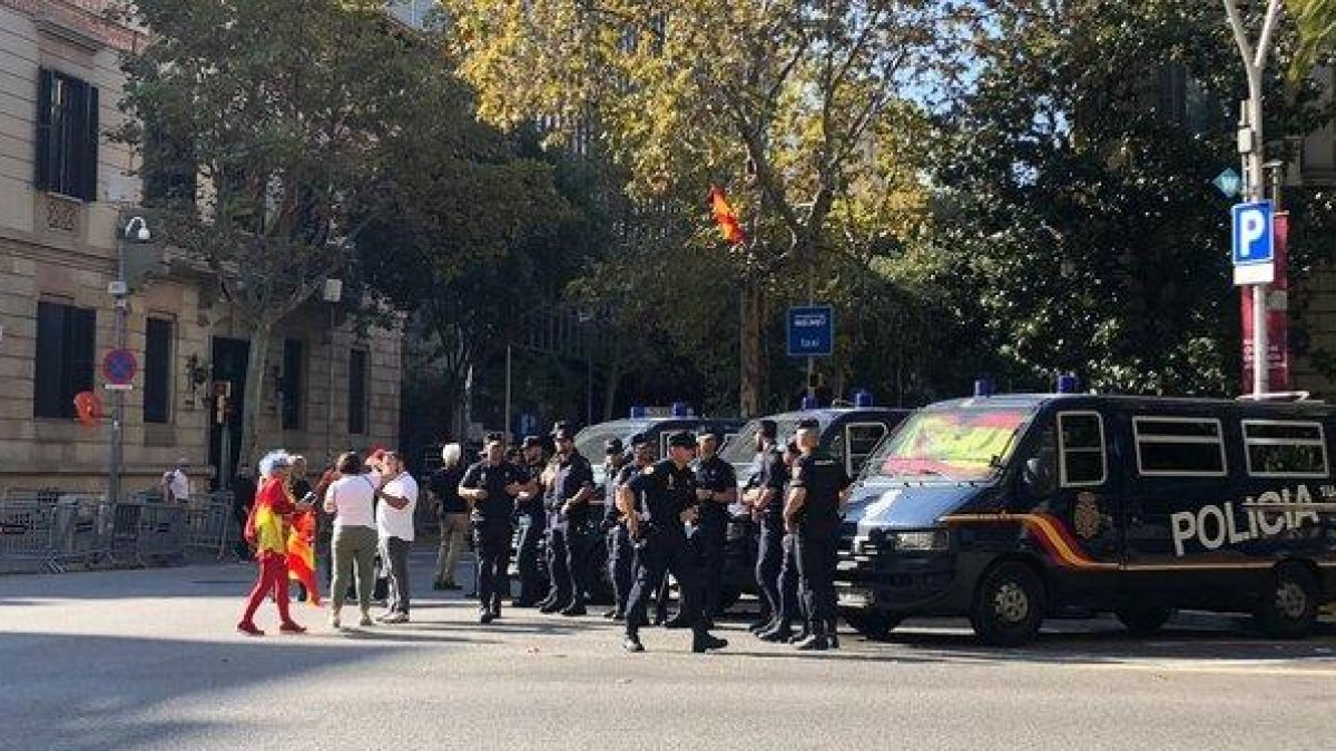 Varias personas saludan a unos agentes de la Policía Nacional, en Barcelona.-JÚLIA REGUÉ