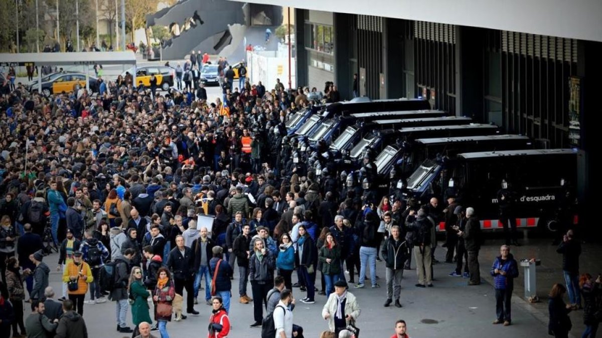 Los mossos controlan los accesos a la estación de Sants, rodeada por manifestantes independentistas.-/ FERRAN NADEU
