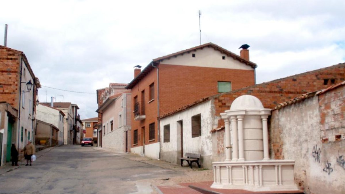 Imagen de una calle de Quintanilla del Agua y a la derecha de la fotografía una fuente.-ECB