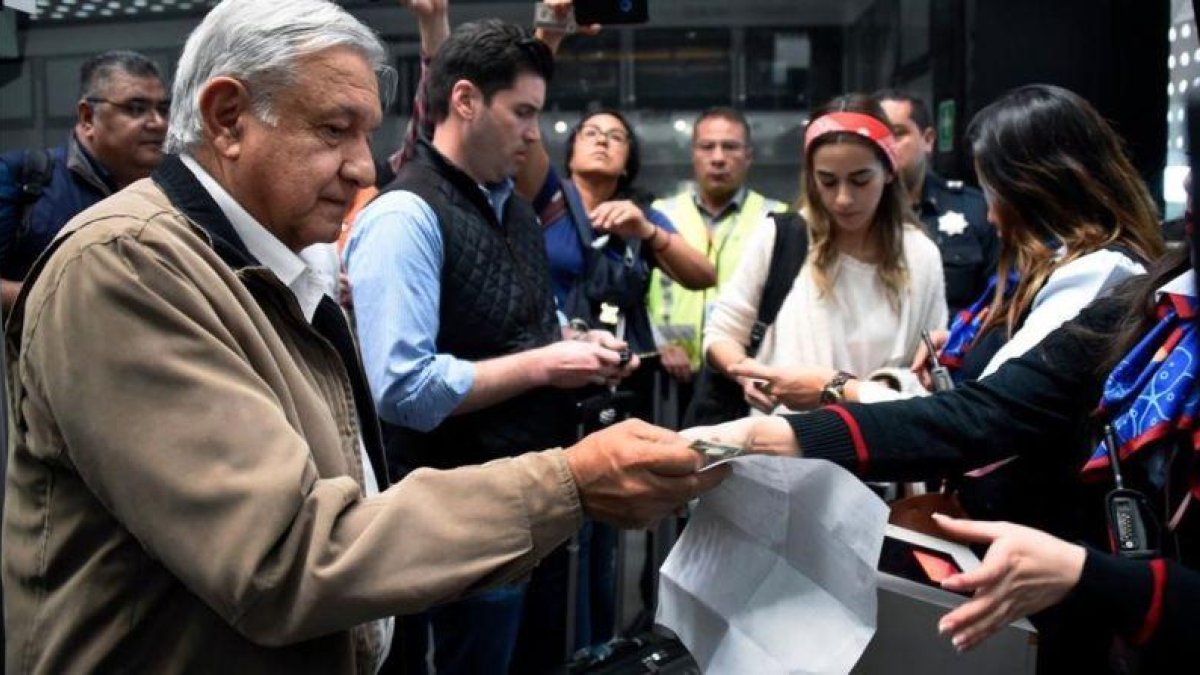 Andrés Manuel López Obrador, presidente de México, recoge su billete de avión antes de embarcar en un vuelo comercial en el aeropuerto internacional de México el 15 de febrero del 2019.-ALFREDO ESTRELLA (AFP)