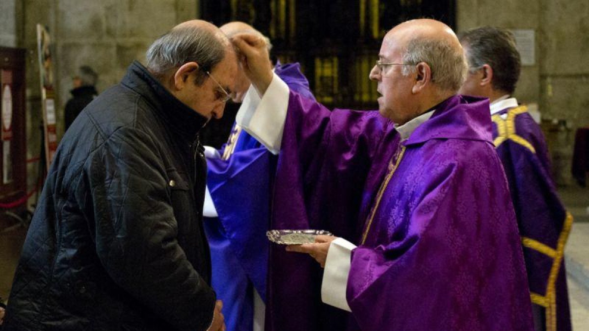 Sacerdote imponiendo la ceniza en la frente de un cristiano que asiste a la celebración del Miércoles de Ceniza.-