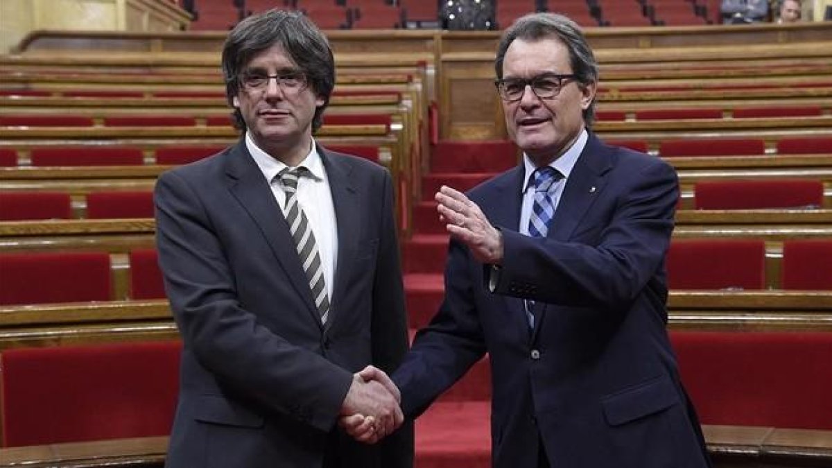 Artur Mas y Carles Puigdemont, tras la investidura del segundo.-AFP / LLUIS GENE