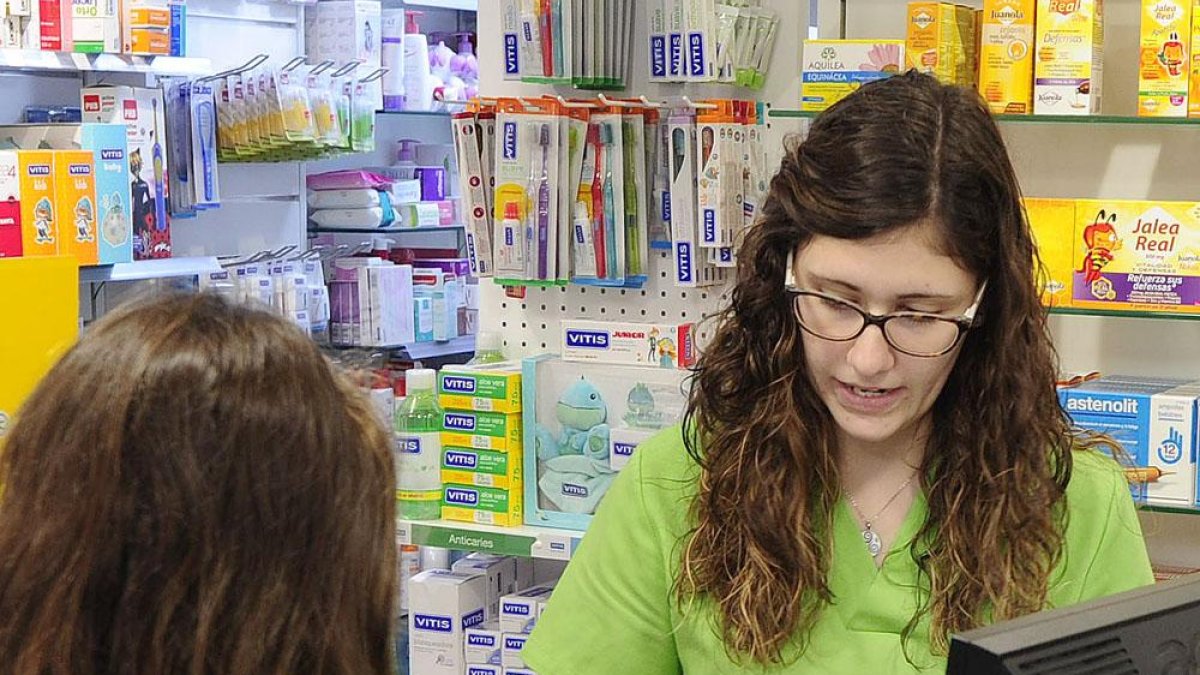 Una mujer adquiere un medicamento en una farmacia.-ISRAEL L. MURILLO