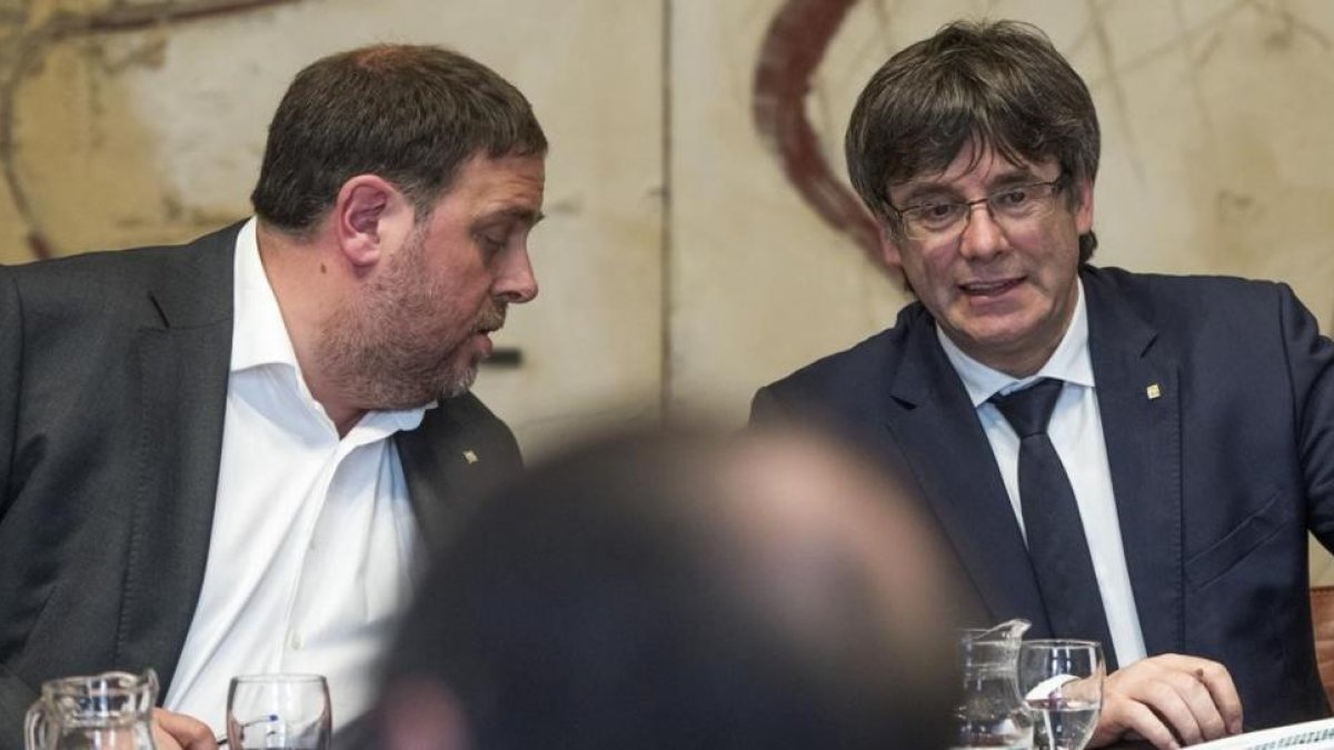 Oriol Junqueras habla con Carles Puigdemont.-FERRAN SENDRA