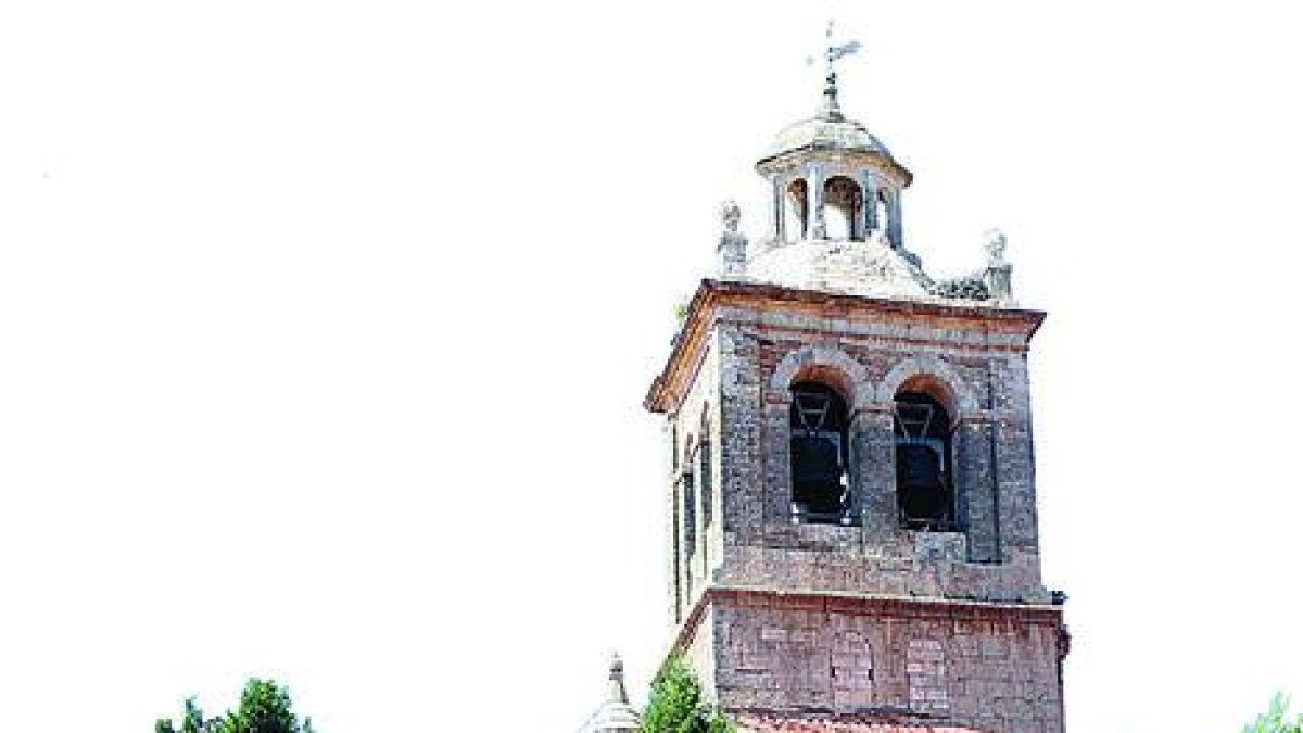 La torre de la iglesia de Santa Cruz surge entre el arbolado.-LUMIAGO