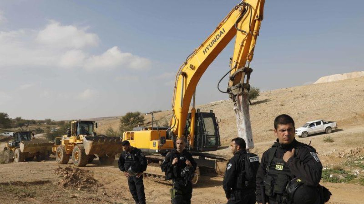 Policías israelís montan guardia junto a excavadoras tras demoler las casas del poblado beduino de Um al Hiran, este miércoles.-AP / TSAFRIR ABAYOV