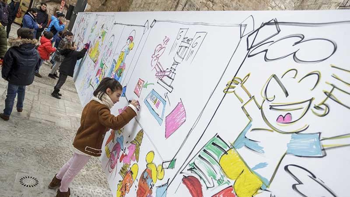 Elia (8 años) participó en el mural iniciado por Álvaro Núñez y después disfrutaría con los dibujos de Olga de Dios. Ella quiere ser como ellos.-Santi Otero
