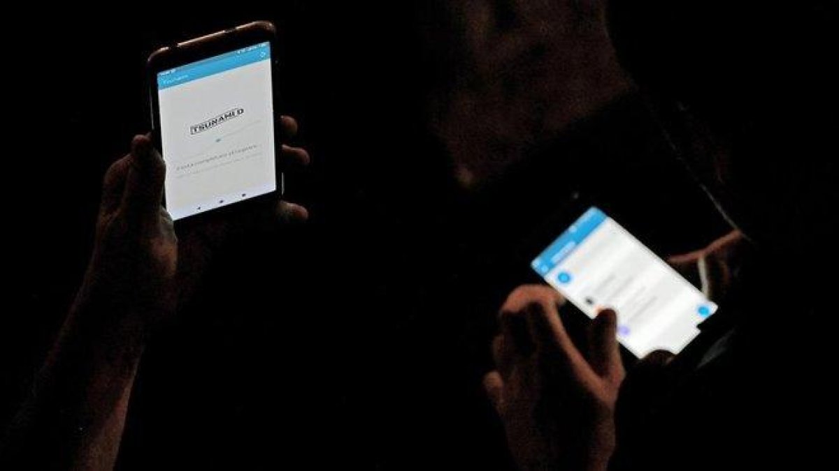 Usuarios consultan la ’app’ de Tsunami Democràtic, este jueves.-AFP / LLUÍS GENE