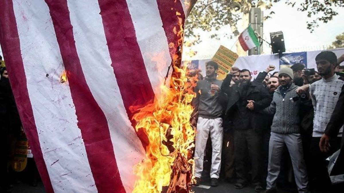 Manifestantes queman la bandera.-REUTERS