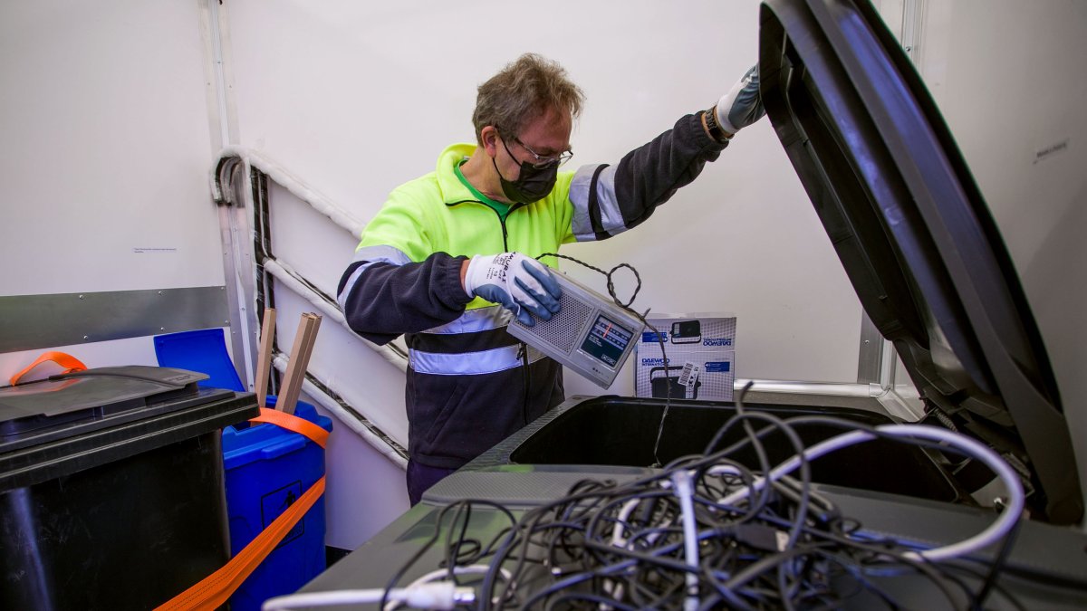 Un operario del punto limpio móvil deposita cables y baterías en un contenedor. TOMÁS ALONSO