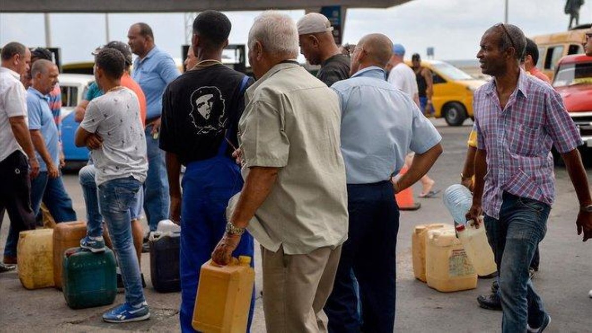 La falta de combustible ha provocado colas de personas en las gasolineras.-AFP / YAMIL LAGE