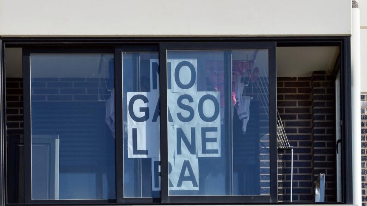Una de las terrazas del edificio de vecinos ubicado junto a la parcela luce un cartel contra la gasolinera.-ISRAEL L. MURILLO