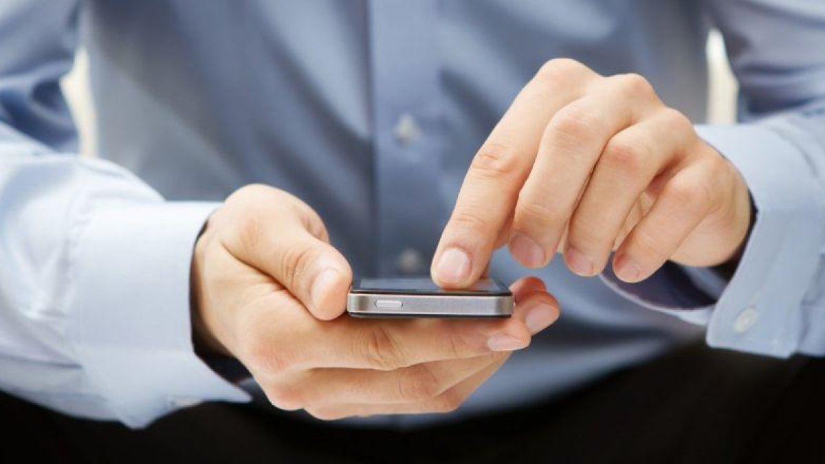 Un usuario consulta su móvil.-EL PERIÓDICO