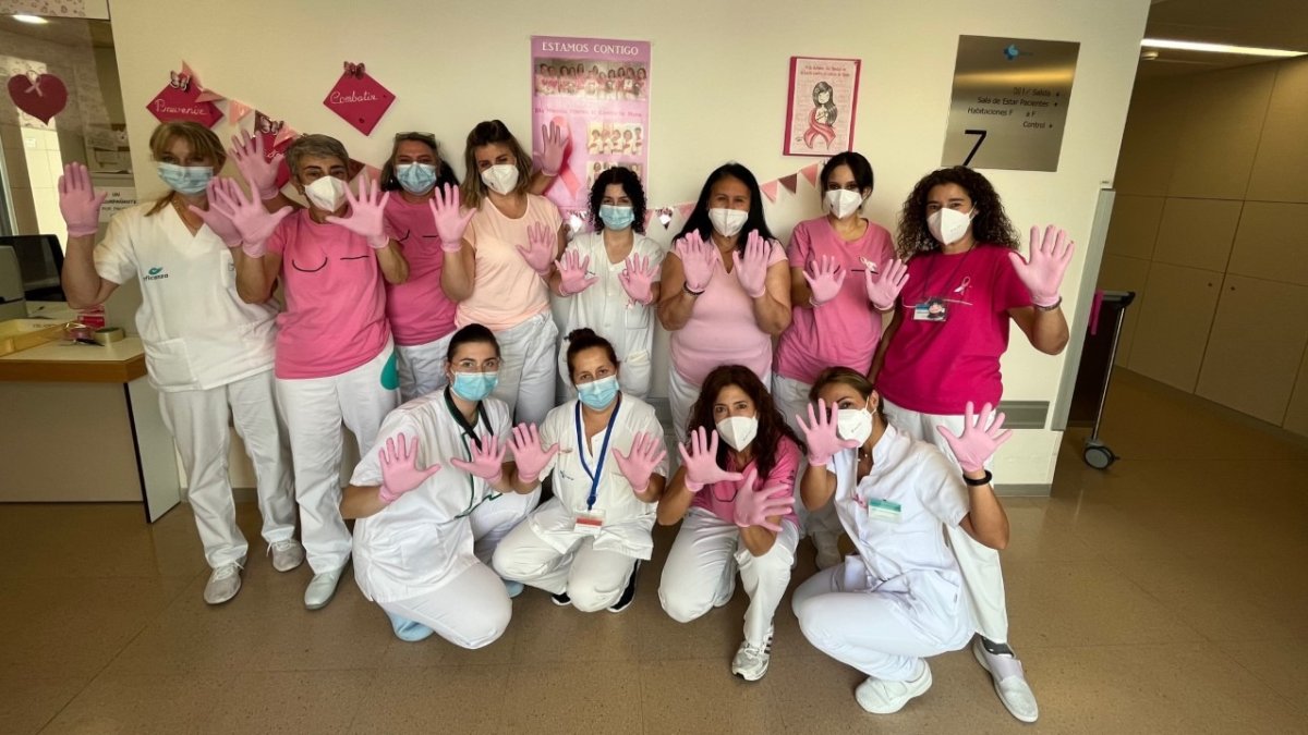 Parte del equipo de Hospitalización de Ginecología posa con los guantes rosas.