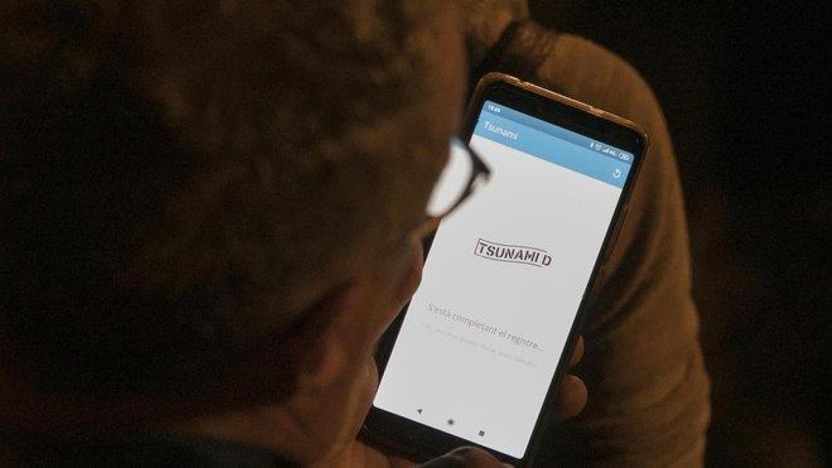 Un usuario consultando la ’app’ de Tsunami Democràtic.-FERRAN NADEU