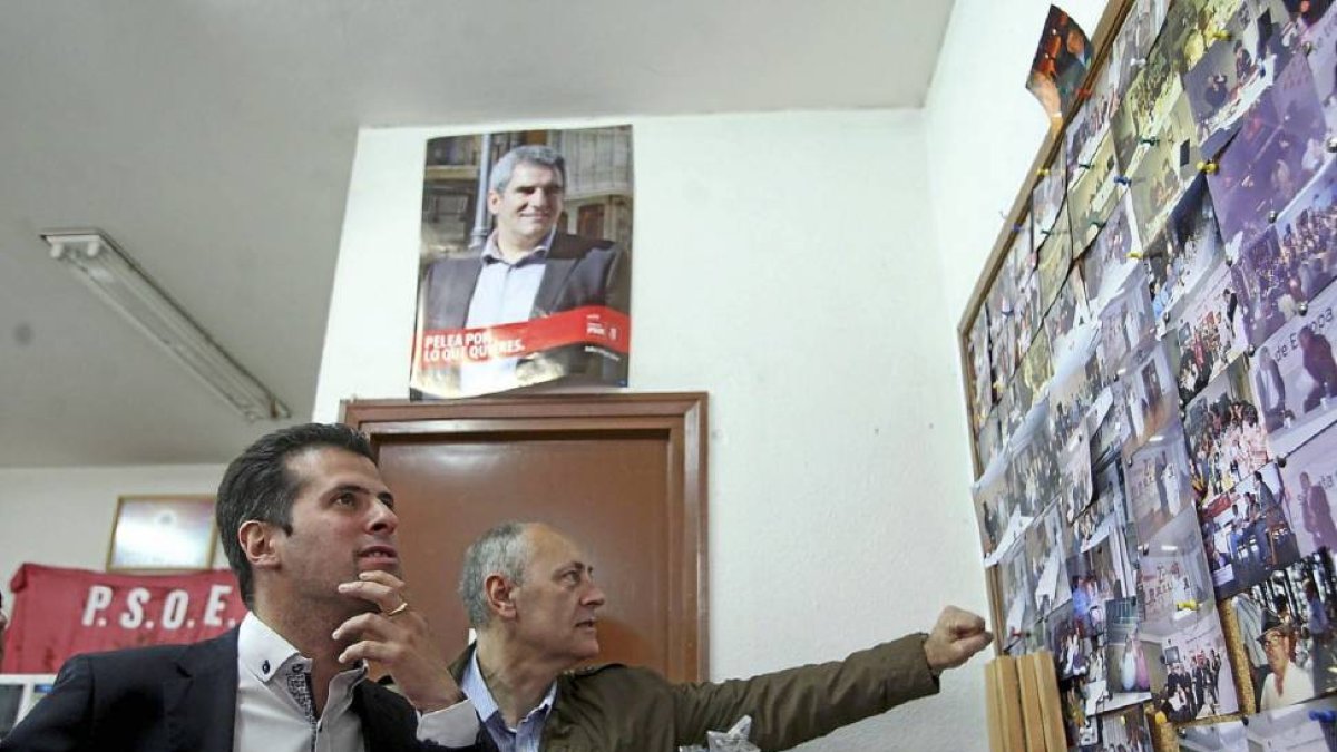 Tudanca, en Guardo, contempla unas fotografías bajo un póster de Villarubia, su rival en las primarias.-Ical