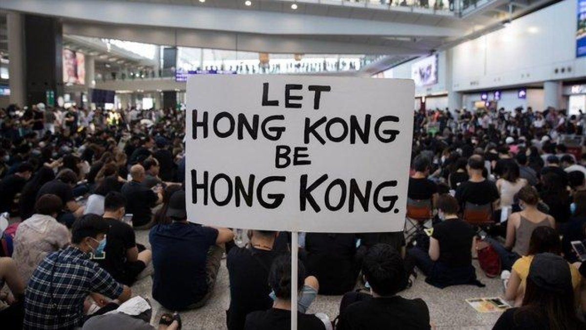 Manifestantes hongkoneses protestan en una sentada en el aeropuerto, este viernes.-JEROME FAVRE (EFE)