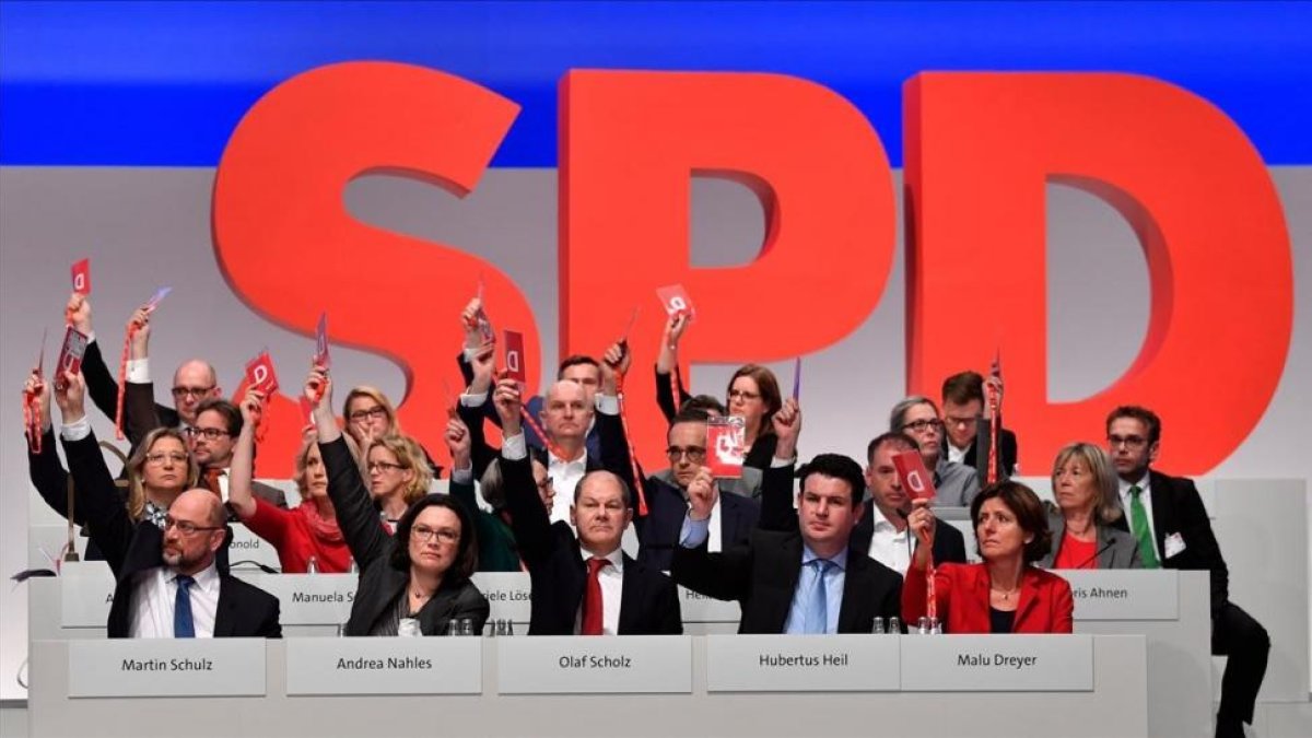 Miembros de la dirección del SPD votan, junto a los demás delegados, a favor de negociar con Merkel.-/ AFP / JOHN MACDOUGALL