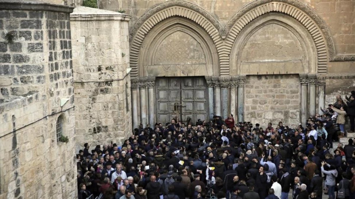 Manifestantes congregados frente a las puertas cerradas de la iglesia del Santo Sepulcro, este martes, 27 de febrero.-AP / MAHMOUD ILLEAN