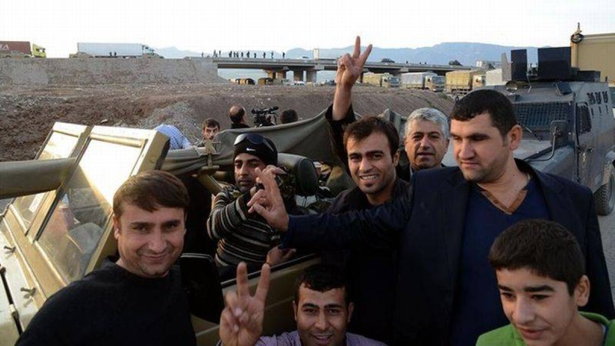 Unos kurdos en Turquía celebran que un convoy de 'peshmerga' haya logrado cruzar la frontera desde Irak.-Foto: AFP / ILYAS AKENGIN