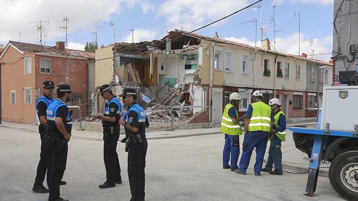 Una brigada de operarios restablece la línea telefónica mientras la Policía Local vigila la casa siniestrada.-RAÚL G. OCHOA