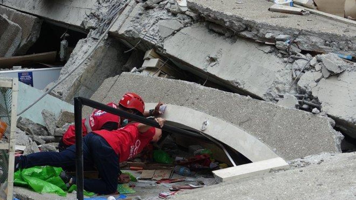 Los equipos de rescate, junto con perros rastreadores, han recuperado por el momento tres cuerpos.-EFE