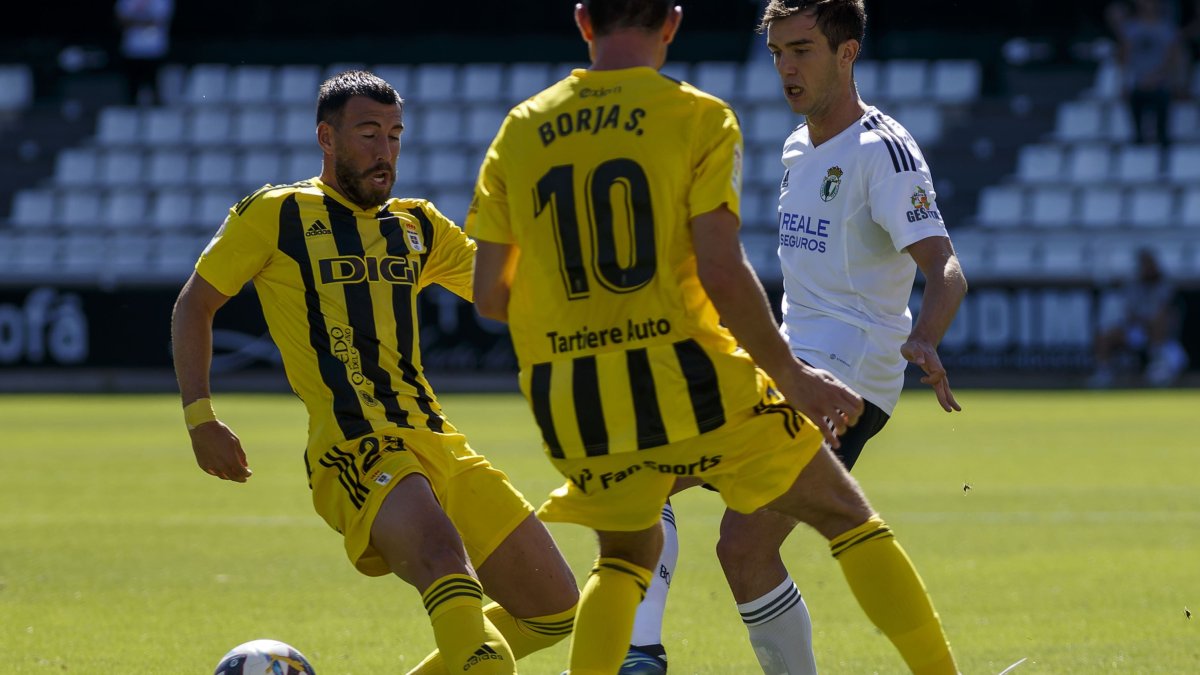 Aitor Córdoba disputa un balón entre dos jugadores del Real Oviedo en el partido de la quinta jornada en El Plantío. S. OTERO