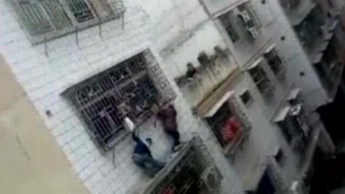 Rescatada una niña en China que se había quedado colgada de un balcón.-