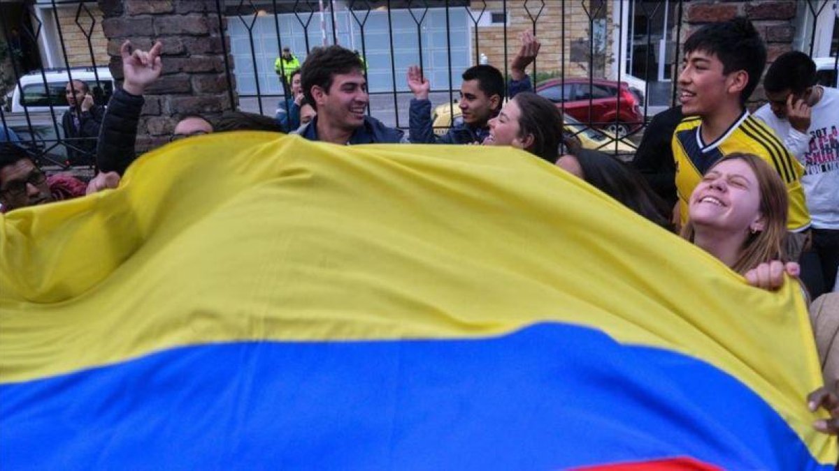 Colombianos celebran con una bandera los resultados del referéndum, en Bogotá.-AFP / DIANA SANCHEZ