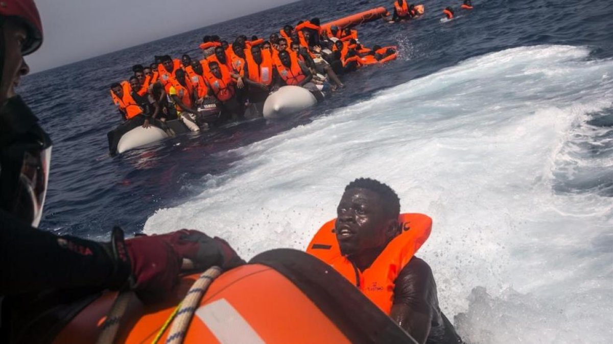 Un inmigrante africano trata de subir al barco de Proactiva Open Arms-SANTI PALACIOS