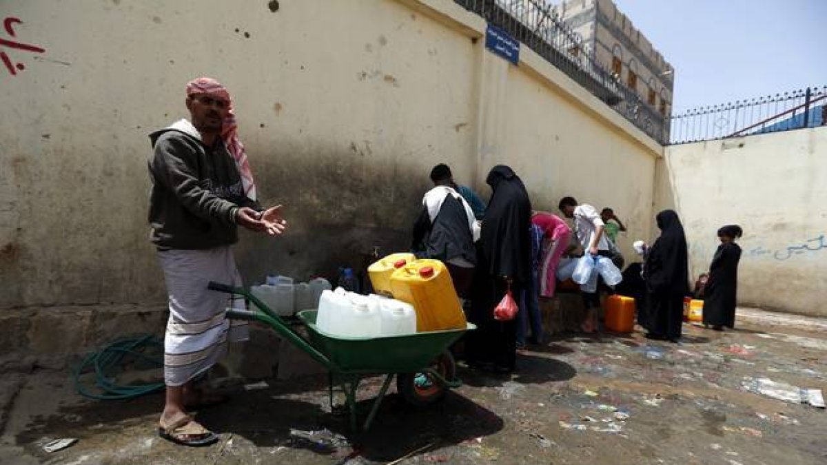 Yemenís llenan de agua potable botellas de plástico en una fuente de Saná.-Foto: EFE / YAHYA ARHAB