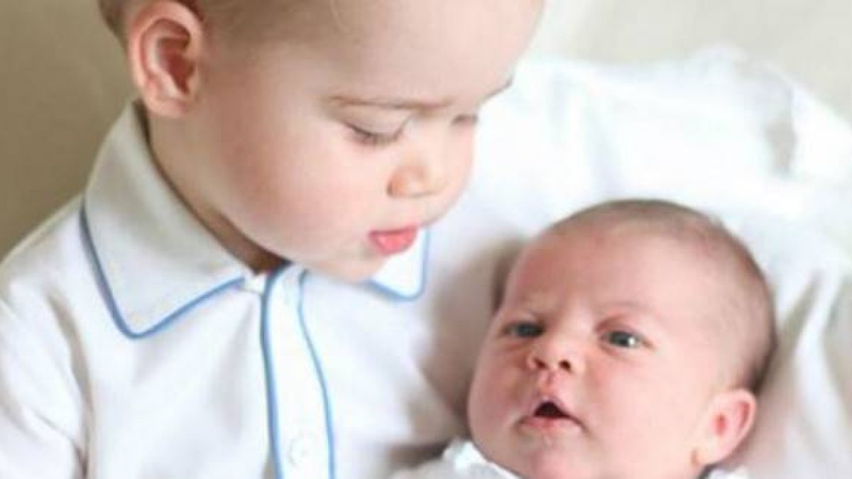Carlota, en brazos de su hermano mayor, Jorge; los hijos de los duques de Cambridge.-Foto:  @KensingtonRoyal