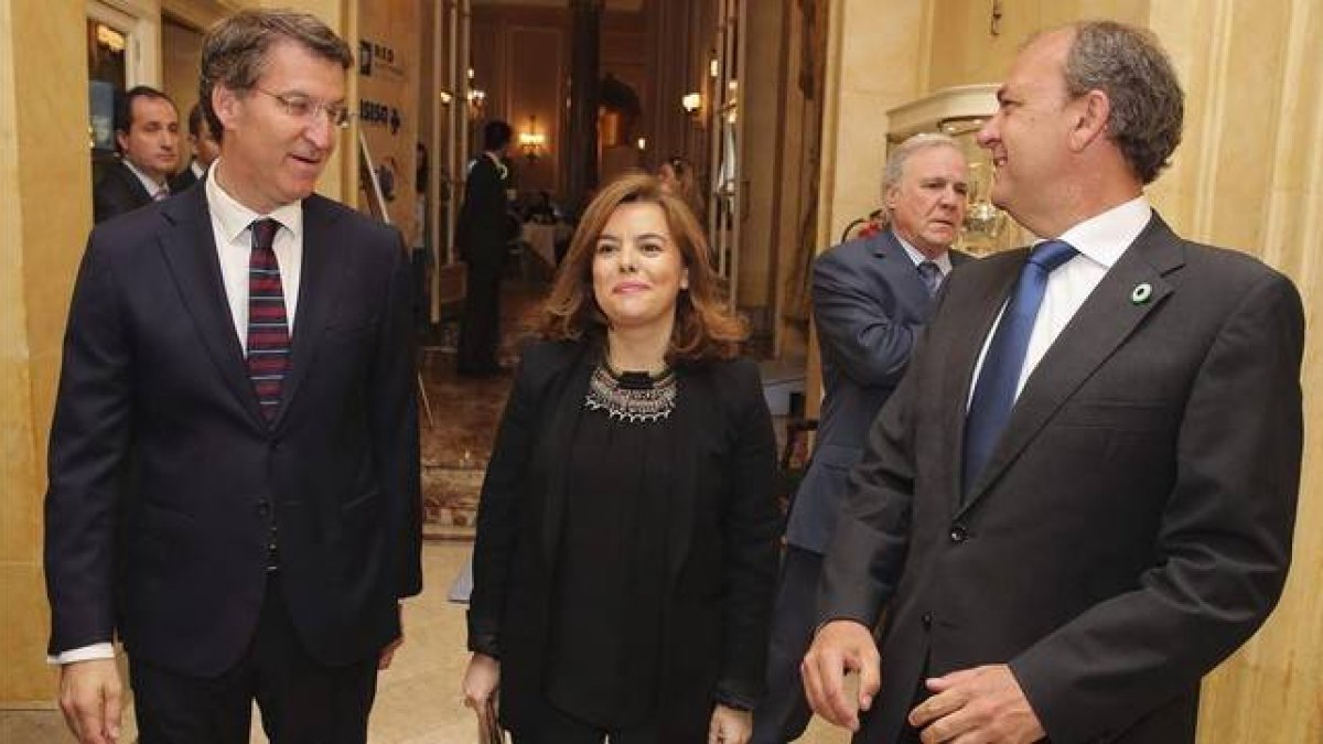 La vicepresidenta Soraya Sáenz de Santamaría, flanqueada por los presidentes gallego y extremeño, Alberto Núñez Feijóo y José Antonio Monago, este lunes en Madrid.-Foto: EFE / BALLESTEROS