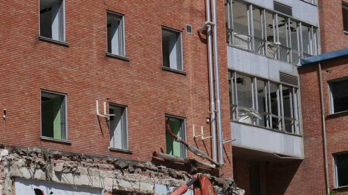 Una excavadora procedía ayer al derribo de parte de la fachada mientras una grúa operaba en lo alto del edificio.-RAÚL G. OCHOA