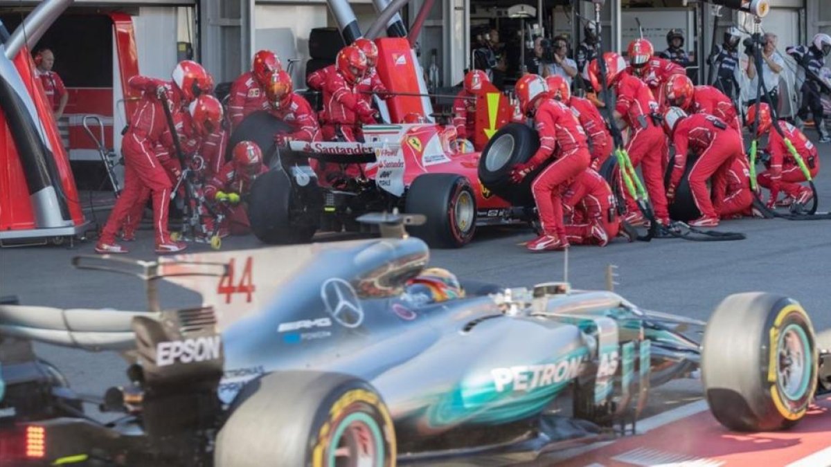 Hamilton pasa por delante de Vettel en un 'pit stop' en Bakú.-AFP / VALDRIN XHEMAJ
