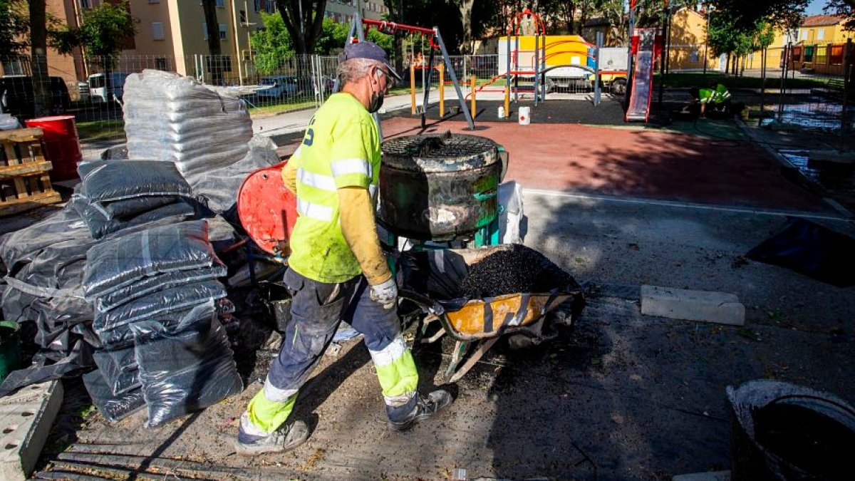 Dos operarios, en la reparación de un parque infantil en la barriada Inmaculada. SANTI OTERO
