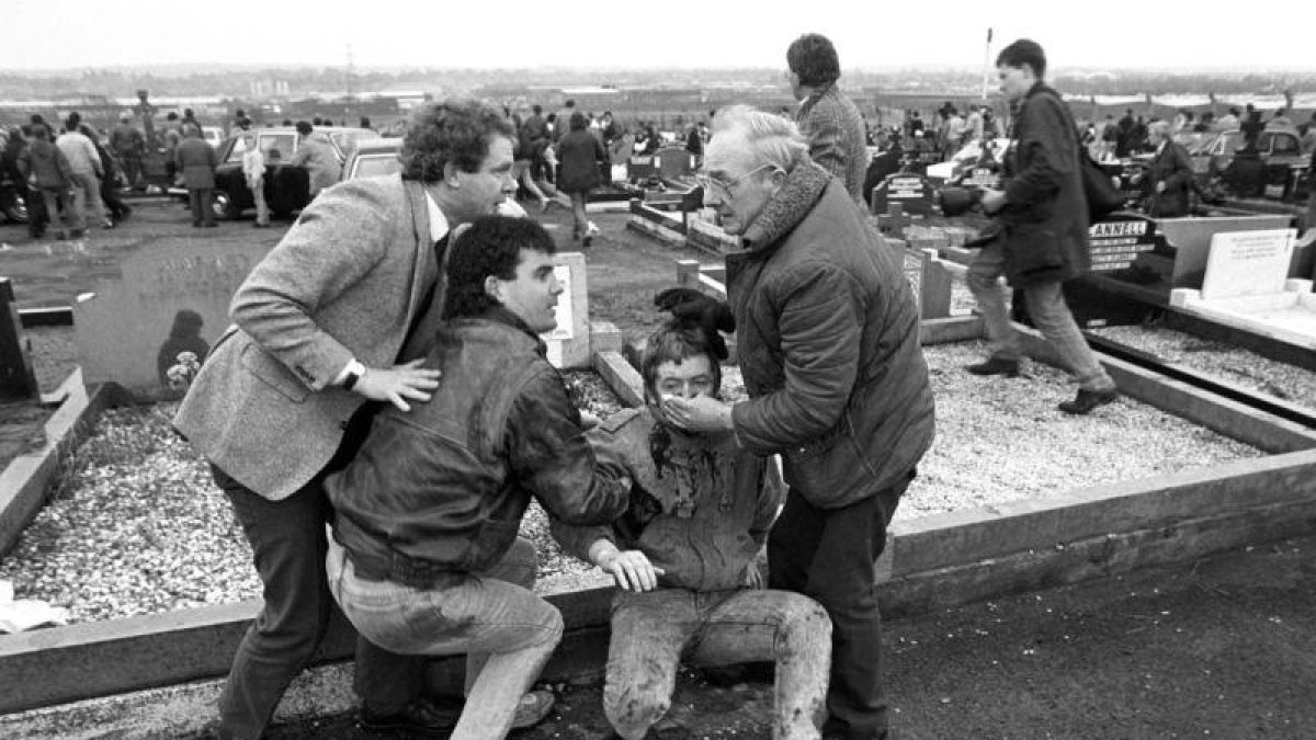 McGuinness, en 1988, ayuda a un herido en un atentado durante el funeral de un miembro del IRA.-DAVID JONES / AP