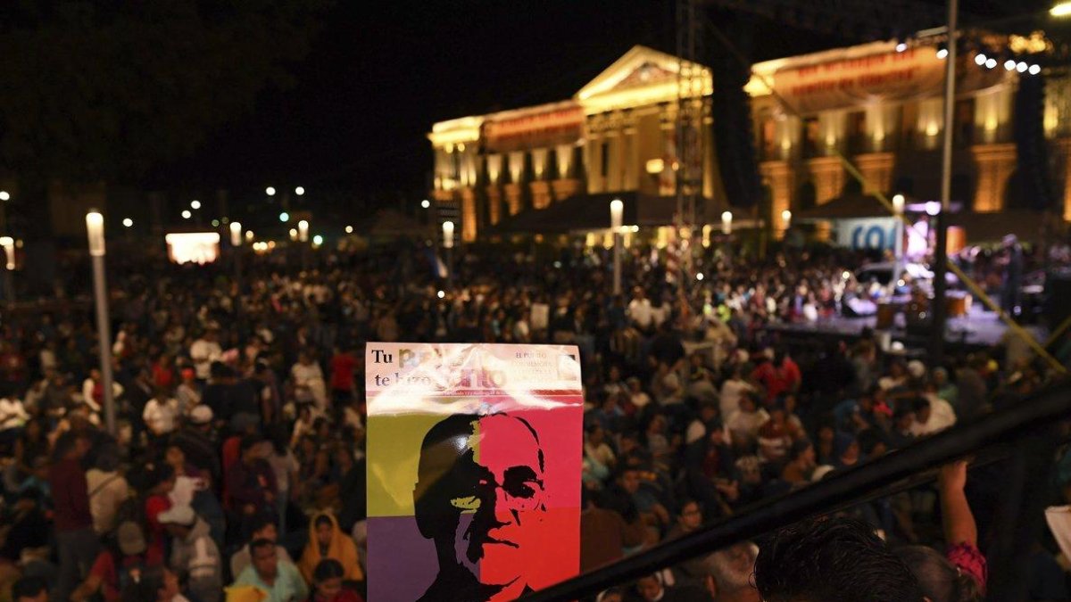 Multitud en San Salvador con un poster serigrafiado con la cara de Óscar Romero-AFP