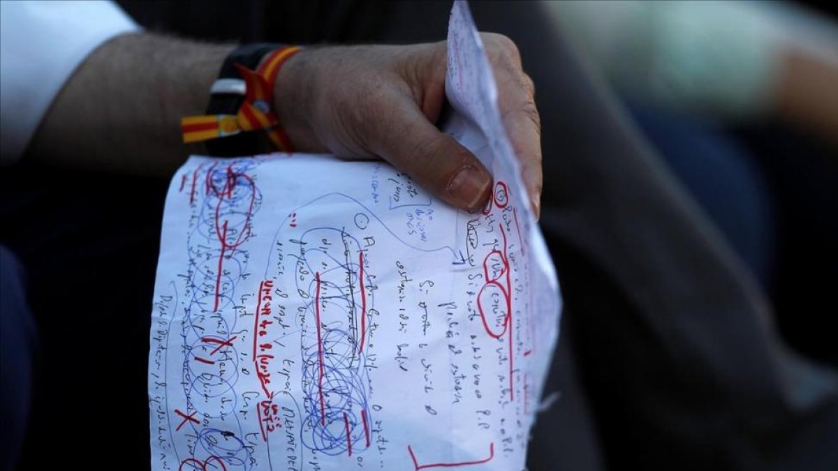 El presidente en funciones y candidato del PP, Mariano Rajoy, repasando unas notas propias antes de intervenir en un mitin en Málaga-JON NAZCA / REUTERS