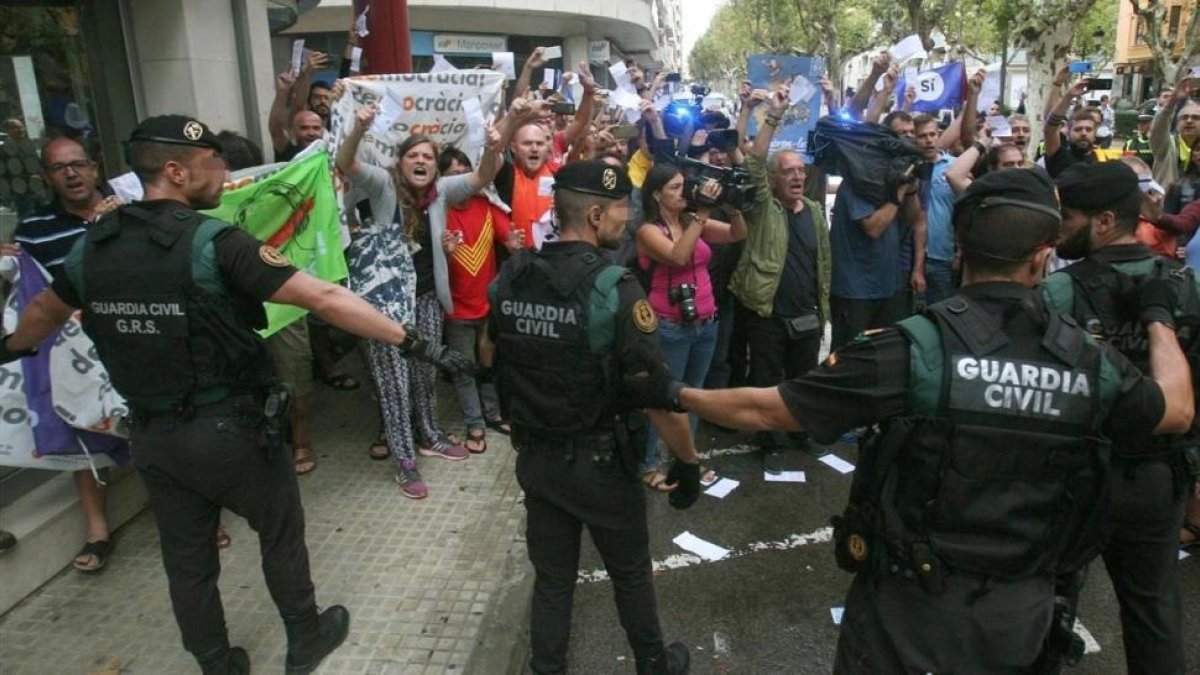 Guardias civiles ante un grupo de manifestantes, durante el registro del semanario El Vallenc-EFE / JAUME SELLART