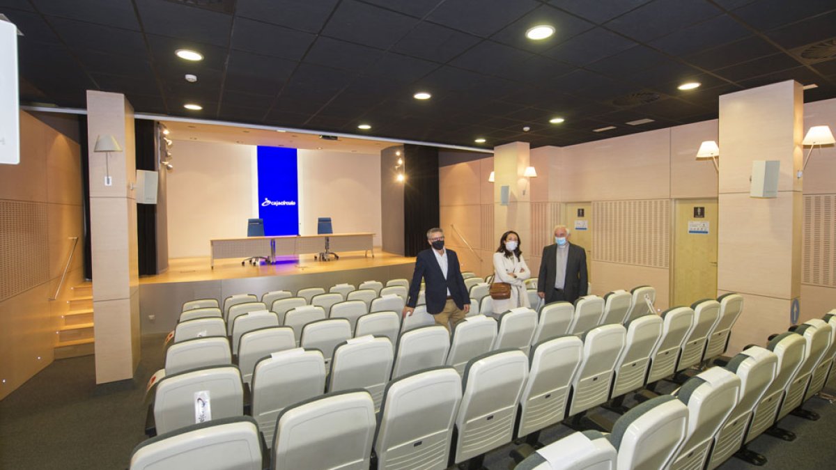Los responsables de la entidad social muestran el salón de actos con que cuenta este espacio formativo en su planta baja. ISRAEL L. MURILLO