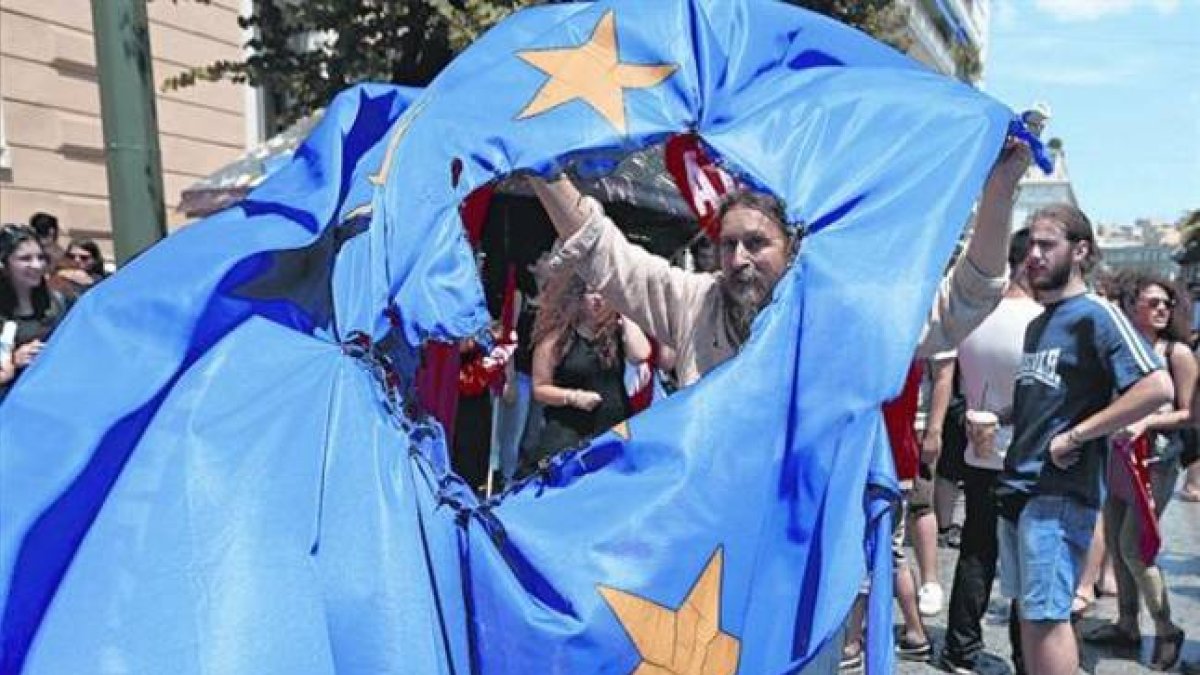 Partidarios del 'no' en el referéndum queman una bendera de la Unión Europea en Grecia durante una protesta en Atenas, ayer.-Foto: EFE / ARMANDO BABANI