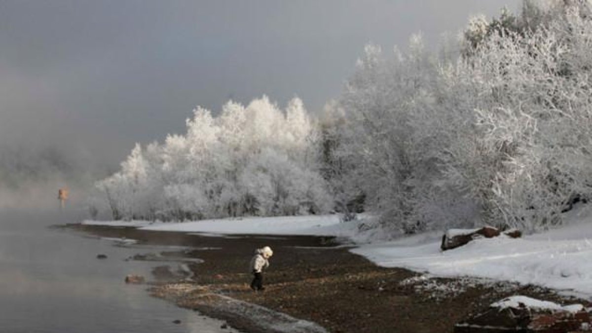 Un niño camina por la orilla del río Yenisei, cerca de la ciudad siberiana de Krasnoyarsk (Rusia), a -23ºC de temperatura.-/ ILYA NAYMUSHIN (REUTERS)