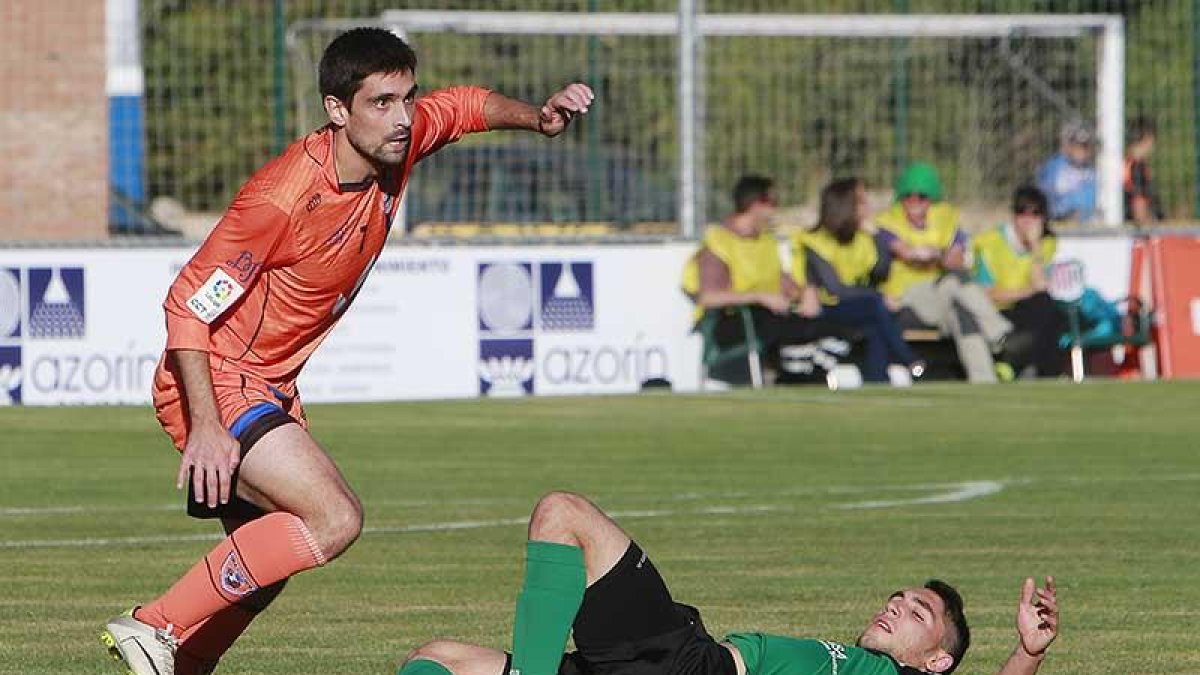 Zamora trata de sortear la entrada de un jugador del Villamuriel en el choque de ayer en Castañares-Raúl G. Ochoa