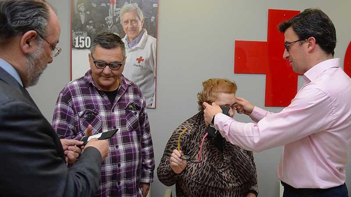 Juan Carlos y Carmen reciben sus gafas de manos del presidente de Cruz Roja en Burgos y del óptico de Multiópticas.-ECB