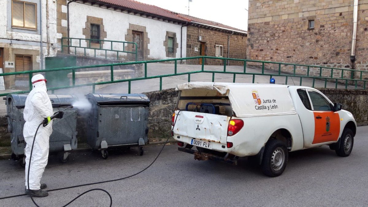 Un operario de la Junta desinfectando contenedores de basura en Quintanar. ECB