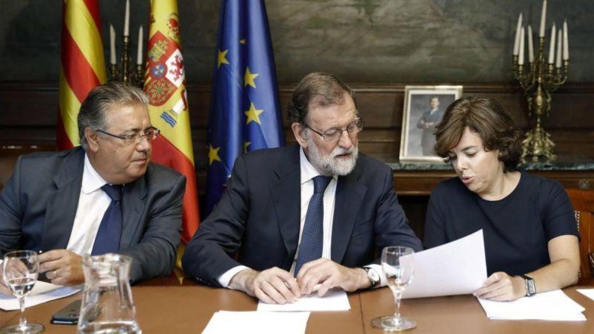 El presidente del Gobierno  Mariano Rajoy , junto al ministro del Interior  Juan Ignacio Zoido  y la vicepresidenta Soraya Saenz de Santamaria.-ANDREU DALMAU/EFE