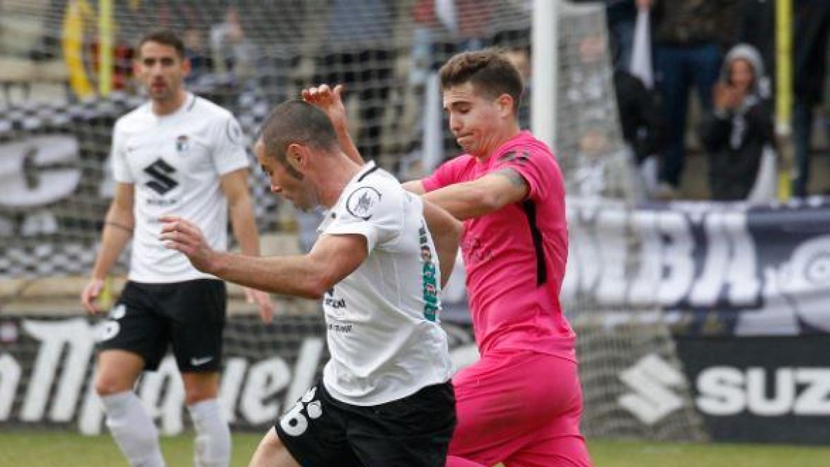 Diego Cervero protege el balón ante la presión de un oponente.-SANTI OTERO