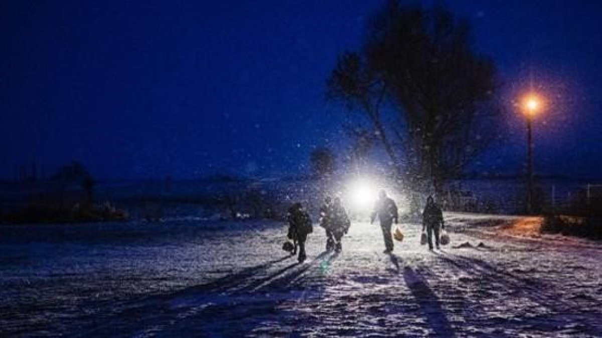 Un grupo de refugiados caminan de noche entre la nieve cerca de la localidad serbia de Miratovac.-AFP / DIMITAR DILKOFF