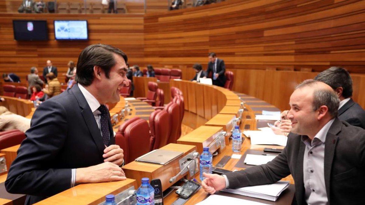 El consejero de Fomento y Medio Ambiente, Juan Carlos Suárez-Quiñones, conversa con el procurador de Ciudadanos, David Castaño, durante el Pleno de las Cortes de Castilla y León-Ical